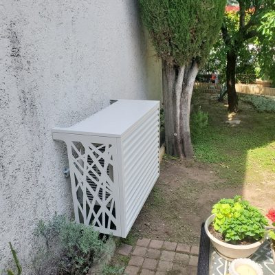 Climatisation avec cache groupe devant un arbre