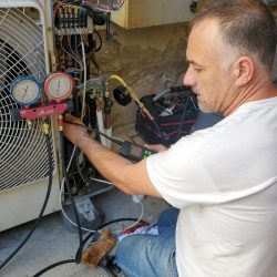 Techicien entretenant un climatiseur