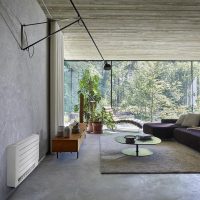 Grand salon à mur gris, baie vitrée et climatiseur blanc